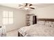 Bright bedroom with white walls, fan, large window, and a bed with patterned pillows at 10825 W El Cortez Pl, Peoria, AZ 85383