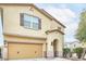Side view of a beige two-story home highlighting the garage and covered entryway in a suburban neighborhood at 10825 W El Cortez Pl, Peoria, AZ 85383