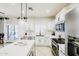 Beautiful kitchen with white cabinetry, stainless steel appliances, and a central island with quartz countertop at 10825 W El Cortez Pl, Peoria, AZ 85383