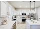 Bright kitchen featuring white cabinets, stainless appliances, quartz counters, and stylish tile backsplash at 10825 W El Cortez Pl, Peoria, AZ 85383