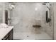 Modern shower with marble-style wall, dual shower heads, and wood bench at 10825 W El Cortez Pl, Peoria, AZ 85383