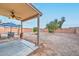 View of the backyard including the covered patio, outdoor table, and ample yard space at 12425 N 127Th Dr, El Mirage, AZ 85335