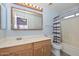 Bright bathroom featuring a wooden-framed mirror, sink vanity, and shower-tub combination at 12425 N 127Th Dr, El Mirage, AZ 85335