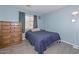 Cozy bedroom showcasing a comfortable bed, wooden dresser, and a floor lamp at 12425 N 127Th Dr, El Mirage, AZ 85335