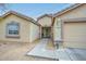 Home exterior featuring a two-car garage, front entryway, and desert-style landscaping at 12425 N 127Th Dr, El Mirage, AZ 85335