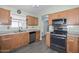 Functional kitchen with stainless steel appliances and wood cabinets, offering ample storage and counter space at 12425 N 127Th Dr, El Mirage, AZ 85335