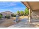 Backyard with a concrete patio area, stainless steel grill and simple desert landscaping at 12607 W Highland Ave, Litchfield Park, AZ 85340