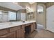Bathroom features dual sinks, vanity, and a glass block window above the tub at 12607 W Highland Ave, Litchfield Park, AZ 85340