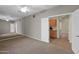 Bedroom with neutral carpet and ceiling fan is open to a hallway and wet bar at 12607 W Highland Ave, Litchfield Park, AZ 85340