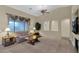 Comfortable living room featuring plush seating, a ceiling fan, and a large window offering plenty of light at 12607 W Highland Ave, Litchfield Park, AZ 85340