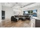 Bright living room featuring a large sectional, coffered ceilings, and wood-look tile flooring with an open kitchen view at 12962 N 145Th Ave, Surprise, AZ 85379