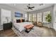 Spacious main bedroom featuring a king bed, plantation shutters, ceiling fan, and wood-style floors at 12970 W Kokopelli Dr, Peoria, AZ 85383