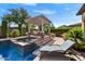 Beautiful pool area featuring an elevated spa and covered patio seating, perfect for relaxing and entertaining at 12970 W Kokopelli Dr, Peoria, AZ 85383