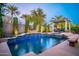 Inviting pool area with a spa and covered patio, surrounded by lush landscaping at 12970 W Kokopelli Dr, Peoria, AZ 85383