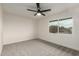 Well-lit bedroom with neutral carpet, ceiling fan, and a large window with outdoor views at 14402 N 34Th Ave, Phoenix, AZ 85053