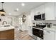 Kitchen area with stainless steel appliances, a microwave, and open shelving at 14402 N 34Th Ave, Phoenix, AZ 85053