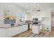 Bright kitchen with white cabinetry, wood-look flooring, granite counters, stainless appliances, and modern light fixtures at 1653 W Morelos St, Chandler, AZ 85224