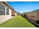 Expansive backyard featuring an artificial lawn, patio and beautiful landscaping at 17165 W Piperton St # 181, Surprise, AZ 85388