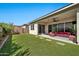 Beautiful backyard featuring a covered patio, artificial lawn and pavers at 17165 W Piperton St # 181, Surprise, AZ 85388