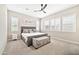 Carpeted primary bedroom with a ceiling fan, shutters and a tufted headboard at 17165 W Piperton St # 181, Surprise, AZ 85388