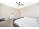 Neutral primary bedroom with a ceiling fan, white dresser and doorway to the Primary bath at 17165 W Piperton St # 181, Surprise, AZ 85388