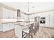 Bright kitchen features white cabinetry, stainless steel appliances, an island with bar seating and tile floors at 17165 W Piperton St # 181, Surprise, AZ 85388