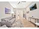 Living room with gray sofa, accent tables, wood-look tile floors, and a TV at 17165 W Piperton St # 181, Surprise, AZ 85388