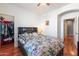 Bright bedroom with a ceiling fan, floral bedding and access to the walk-in closet at 17286 W Morning Glory St, Goodyear, AZ 85338