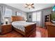 Spacious main bedroom featuring wood floors, a ceiling fan, and a large carved-wood headboard at 17286 W Morning Glory St, Goodyear, AZ 85338