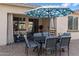 Comfortable outdoor patio space for dining and entertaining with shade from an umbrella at 17286 W Morning Glory St, Goodyear, AZ 85338