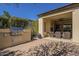 Backyard showing a built-in grill area, manicured landscaping, and a covered outdoor seating space at 1775 E Tangelo Pl, Queen Creek, AZ 85140