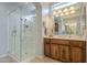 Bright bathroom featuring glass-enclosed shower and double sink vanity with custom wood cabinetry at 1775 E Tangelo Pl, Queen Creek, AZ 85140