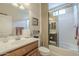 Well-lit bathroom boasts a glass enclosed tub/shower, vanity with modern faucet and stylish decor at 1775 E Tangelo Pl, Queen Creek, AZ 85140
