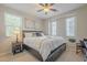 Charming bedroom with a decorative ceiling fan, large windows and stylish bedside table with lamp at 1775 E Tangelo Pl, Queen Creek, AZ 85140