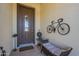 Welcoming front porch with decorative wall art, bench, and a stylish brown front door at 1775 E Tangelo Pl, Queen Creek, AZ 85140