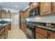 Spacious kitchen featuring a gas range, tile backsplash, and black countertops at 1775 E Tangelo Pl, Queen Creek, AZ 85140