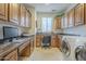 Functional laundry room equipped with washer, dryer, ample counter space, cabinets, and a workspace at 1775 E Tangelo Pl, Queen Creek, AZ 85140