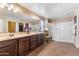 Bright bathroom featuring a double vanity, large mirror, and glass-enclosed shower at 20728 W Legend Trl, Buckeye, AZ 85396