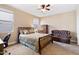 Bedroom with carpet, ceiling fan, dresser, and sitting area with leather couch at 20728 W Legend Trl, Buckeye, AZ 85396