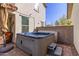 A cozy outdoor patio featuring a modern hot tub, a comfortable seating area, and a well-maintained brick surround at 20728 W Legend Trl, Buckeye, AZ 85396