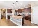 The kitchen features dark cabinets, a tile backsplash, stainless steel appliances, and a center island at 20728 W Legend Trl, Buckeye, AZ 85396
