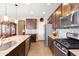 Kitchen with stainless steel appliances, granite countertops, a tile backsplash, and dark wood cabinets at 20728 W Legend Trl, Buckeye, AZ 85396