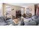 Comfortable living room with a gray sectional sofa, TV, and large windows for natural light at 20728 W Legend Trl, Buckeye, AZ 85396