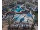 Aerial view of resort style community pool with palm trees, lounge chairs, and water features at 20728 W Legend Trl, Buckeye, AZ 85396