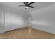 Bedroom with a closet with white sliding doors, wood-look floors, and a ceiling fan at 248 S 95Th Pl, Chandler, AZ 85224