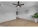 Empty living room with wood-look floors, a ceiling fan, and a wall decoration at 248 S 95Th Pl, Chandler, AZ 85224