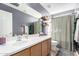 Spacious bathroom with large mirror, wood cabinets, and bathtub with curtain at 26111 W Yukon Dr, Buckeye, AZ 85396