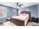 Comfortable bedroom with blue walls, ceiling fan, and queen-sized bed at 26111 W Yukon Dr, Buckeye, AZ 85396