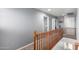 Upstairs hallway with wooden banister and grey walls at 26111 W Yukon Dr, Buckeye, AZ 85396