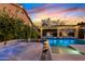 Inviting backyard with a pool, hot tub, and string lights, ideal for evening gatherings and relaxation at 2733 E Virginia St, Gilbert, AZ 85296